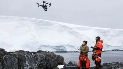 Royal Navy Lt Cdr Kate Retallick and LMet Ross Lovejoy fly the drone to collect aerial imagery of the penguin colony.