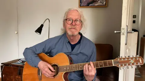 Chris Burston playing the guitar