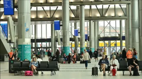 Interior of Grand Central Station with passengers sat in seats 