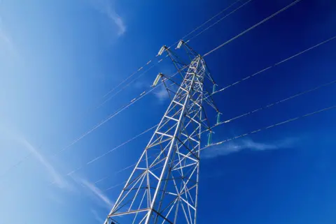 A large electricity pylon with cables against a blue sky