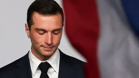 Reuters A dejected Jordan Bardella - a far right French politician - looks down at the ground.