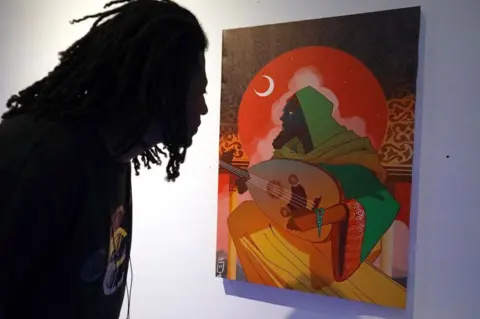 AFP A visitor looks at an artwork by Libyan artist Abdullah Hadia during the Tra Tani exhibition, a puzzle game consisting of artworks by local artists, in Libya's eastern city of Benghazi on July 3, 2022.