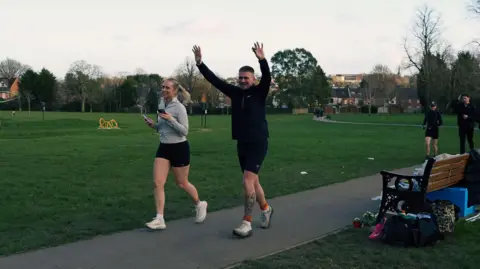 LAURENCE DENIS A man wearing an all black running outfit in a park