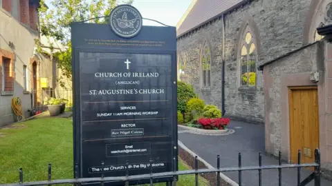 A sign sits in the rounds of the church,