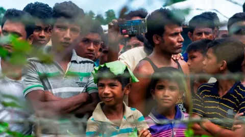 Getty Images Rohingya refugees gather near the fence in the "no man's land" between Myanmar and Bangladesh border as seen from Maungdaw, Rakhine state, on June 29, 2018