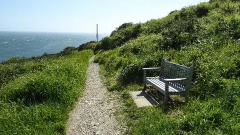 Wednesday - a bench looks out over the sea at Swanage surrounded by greenery