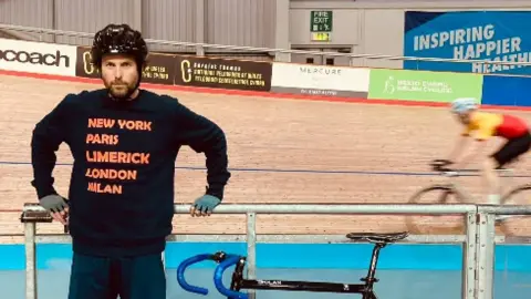 Ben Aitken A man in a black jumper, which is written on it New York, Paris, Limerick, London, Milan at the Newport velodrome