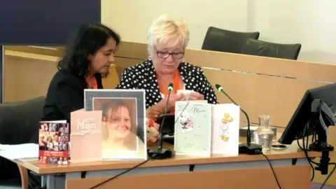 LAMPARD INQUIRY/YOUTUBE Martha Gaskell reading a statement regarding the death of her daughter Marion Turner at the Lampard Inquiry at the Civic Centre in Chelmsford.  She has her solicitor Priya Singh beside her and there are photos of her daughter and birthday cards from her daughter placed on the table in front of her.