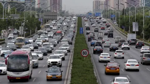 Reuters Cars berkendara di jalan selama jam sibuk pagi hari di Beijing