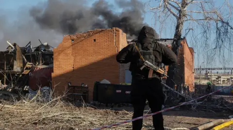 A police officer stands at the site of a Russian strike in Brovary, near Kyiv, Ukraine, 14 March 2026.