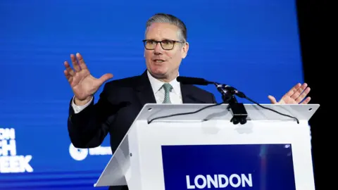 Sir Keir Starmer talking at a lectern which says London in white writing against a blue background