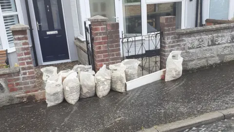 Sharon Powles Sand bags outside partially flooded home