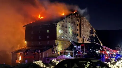 Firefighters work to extinguish a fire at a hotel in the ski resort of Kartalkaya in Bolu, Turkey