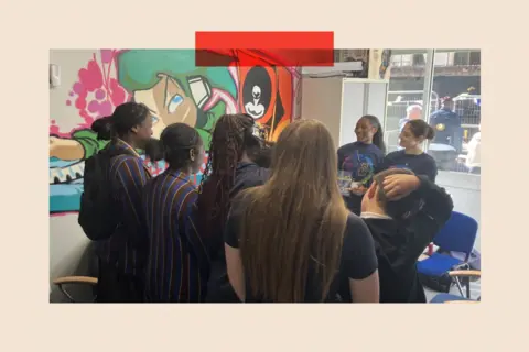 A group of girls huddle together in Youth Unity