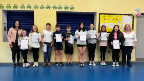 Photo de groupe de la classe souriante avec ses résultats