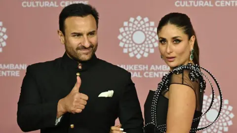 Getty Images In this picture taken on April 1, 2023, Bollywood actors Saif Ali Khan (L) and Kareena Kapoor poses for pictures during the inauguration of the Nita Mukesh Ambani Cultural Centre (NMACC) at the Jio World Centre (JWC) in Mumbai. (Photo by SUJIT JAISWAL / AFP) (Photo by SUJIT JAISWAL/AFP via Getty Images)
