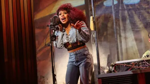Alexandra Burke on stage performing as Chaka Khan