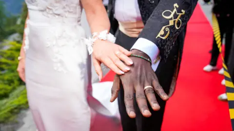 Reuters Norway's Princess Martha Louise and Durek Verrett show their wedding rings and an entwined M and D embroidered in gold on Mr Verrett's suit sleeve