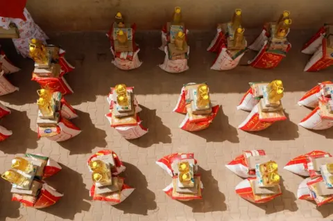 Reuters Sack of rice, bottles of cooking oil, plus other provisions are neatly stacked in piles on the ground.