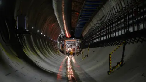 PA Media An image inside of the Euston Tunnel, part of the HS2 high-speed railway project. A yellow vehicle is visible at the end of the tunnel.