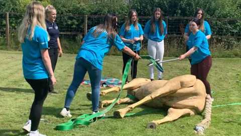 Children helping a fake horse