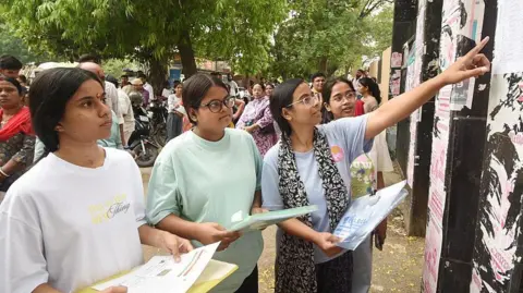 Aspirants looking seat plan before appearing in the National Eligibility cum Entrance Test (NEET) UG 2026 exam conducted by National Testing Agency (NTA) at an examination centre, Magadh Mahila College on May 3, 2026 in Patna, India. 