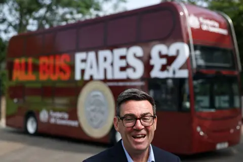 Getty Images Andy Burnham in front of a bus 
