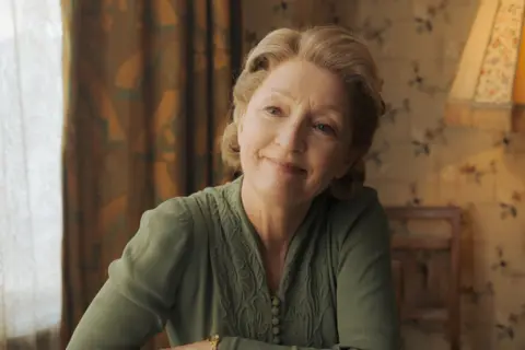 Warren Orchard/ Icon Film Distribution Lesley Manville as Ma Smith in a green dress, smiling 