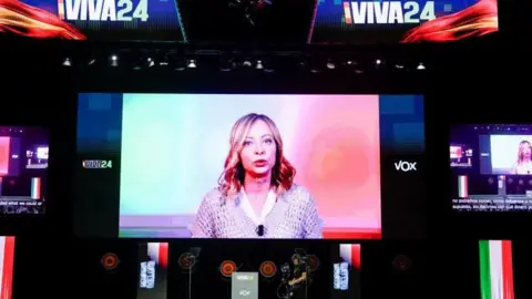 REUTERS/Ana Beltran Italian Prime Minister Giorgia Meloni speaks via video link during a rally organised by the Spanish far-right Vox party ahead of the European elections