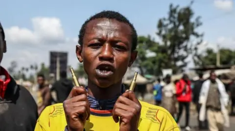 A close-up of a protester holding two spent bullets in Nairobi 