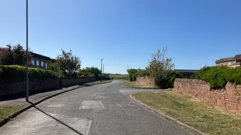 The address at which Skyline PM had been registered on Pinfold Lane in Hoylake, close to Royal Liverpool Golf Club, did not exist
A cul-de-sac called Pinfold Lane. It is a short road leading to a gate, through which is the course of the Royal Liverpool Golf Club. There are low walls on either side of the grass verges.