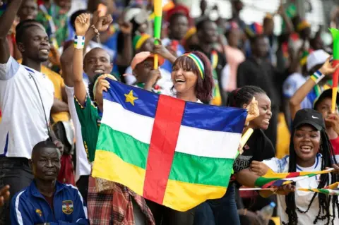 Daniel Beloumou Olomo/AFP Central African Republic supporters cheers and wave flags in the stands.