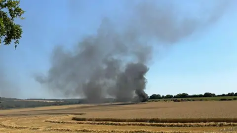 Oxfordshire Fire and Rescue Service thick, black smoke rising from a field in the distance