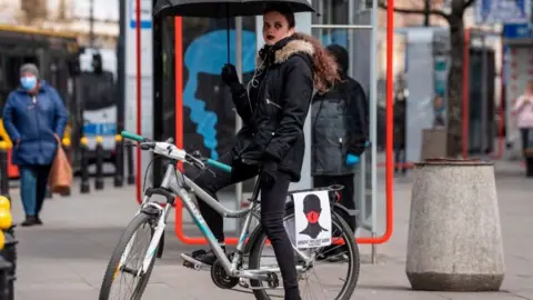 Getty Images People attached posters to cars and bikes to circumvent a ban on public gatherings