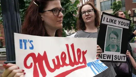 Getty Images Activists hold signs during a protest outside court prior to the first day of the trial of former Trump campaign chairman Paul Manafort July 31, 2018 in Alexandria, Virginia