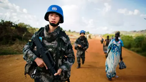 Getty Images Chinese peacekeeping troops walk along a road in South Sudan