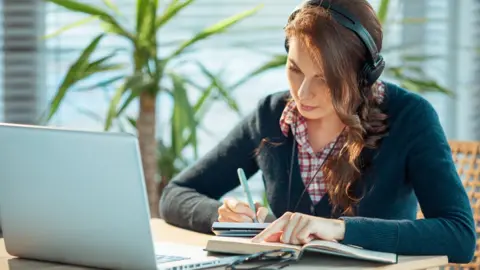Getty Images Girl studying with headphones on