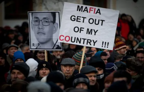 AFP/Getty Images People hold placards during a silent protest march in Bratislava