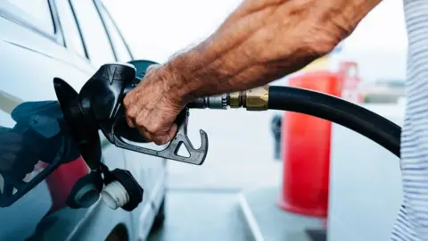 Getty Images Man filling up with petrol