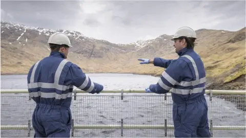 Getty Images Two workers on a dam