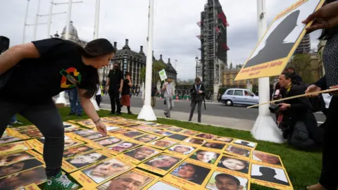 AFP/Getty Campaigners display photos of the victims of the Grenfell Tower fire outside the Houses of Parliament