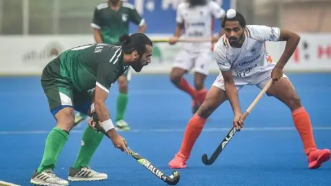 Getty Images Pakistan's Ali Shan (L) and India's Gursahibjit Singh (R) fight for the ball during the men's field hockey third place match between India and Pakistan at the Asian Championship Trophy tournament in Dhaka on December 22, 2021