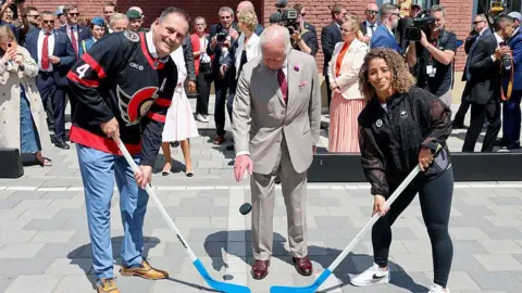 Getty Images King Charles III drops the puck to launch the hockey match at a community event in Lansdowne Park during an official visit to Canada on May 26, 2025 in Ottawa, Ontario.