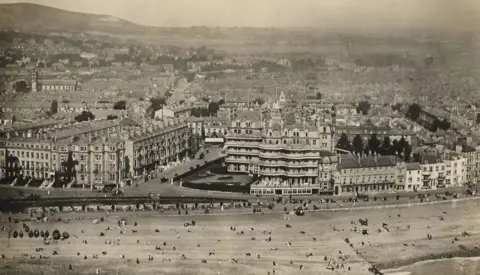 The Queens Hotel in Eastbourne during the 1900s. The black and white image shows the hotel, which is on the seafront.