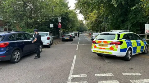 BBC/Aruna Iyengar The bottom of Sally Port road, taped off by police tape with a police car on the scene