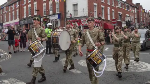 Laura Minor A group of soldiers with instruments parade through Stourport