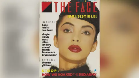 The Face Front cover of The Face magazine showing Sade with a black hat and deep red lipstick. The Magazine description says: "Sade lets her hair down" and "Simple Minds, Matt Dillon, Ian Dury, Aswad, French & Saunders and Bruce Weber." It also says "Style: The new glitterati". 