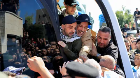 Reuters Palestinian prisoners released in exchange for Israeli hostages under the Gaza ceasefire deal react after being transported by a coach to Ramallah, in the occupied West Bank (13 October 2025)