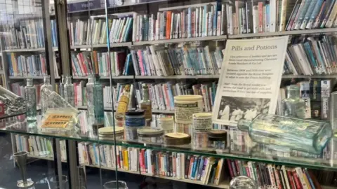 Royal Wolverhampton NHS Trust A glass cabinet of healthcare memorabilia, including glass bottles and jars 