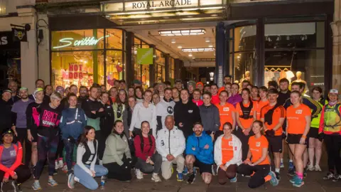 Mark Lewis about 71 runners in Luminous Sportswear for a photo outside the Royal Arcade in Cardiff. 